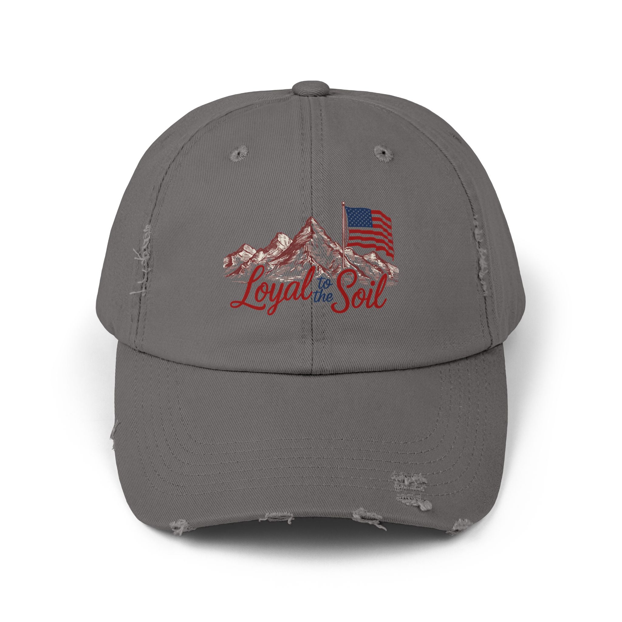 A beige distressed baseball cap with a 'Loyal to the Soil' graphic, featuring a mountain range and an American flag.