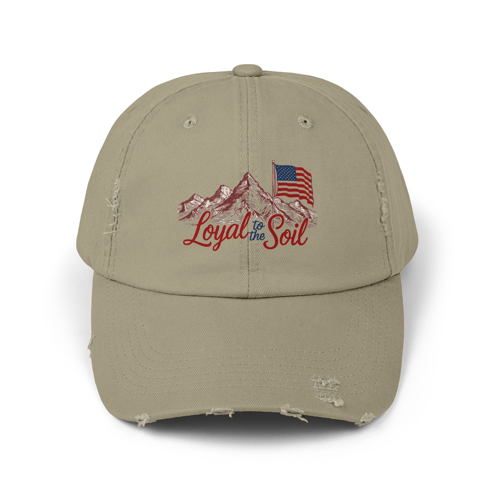 A beige distressed baseball cap with a 'Loyal to the Soil' graphic, featuring a mountain range and an American flag.