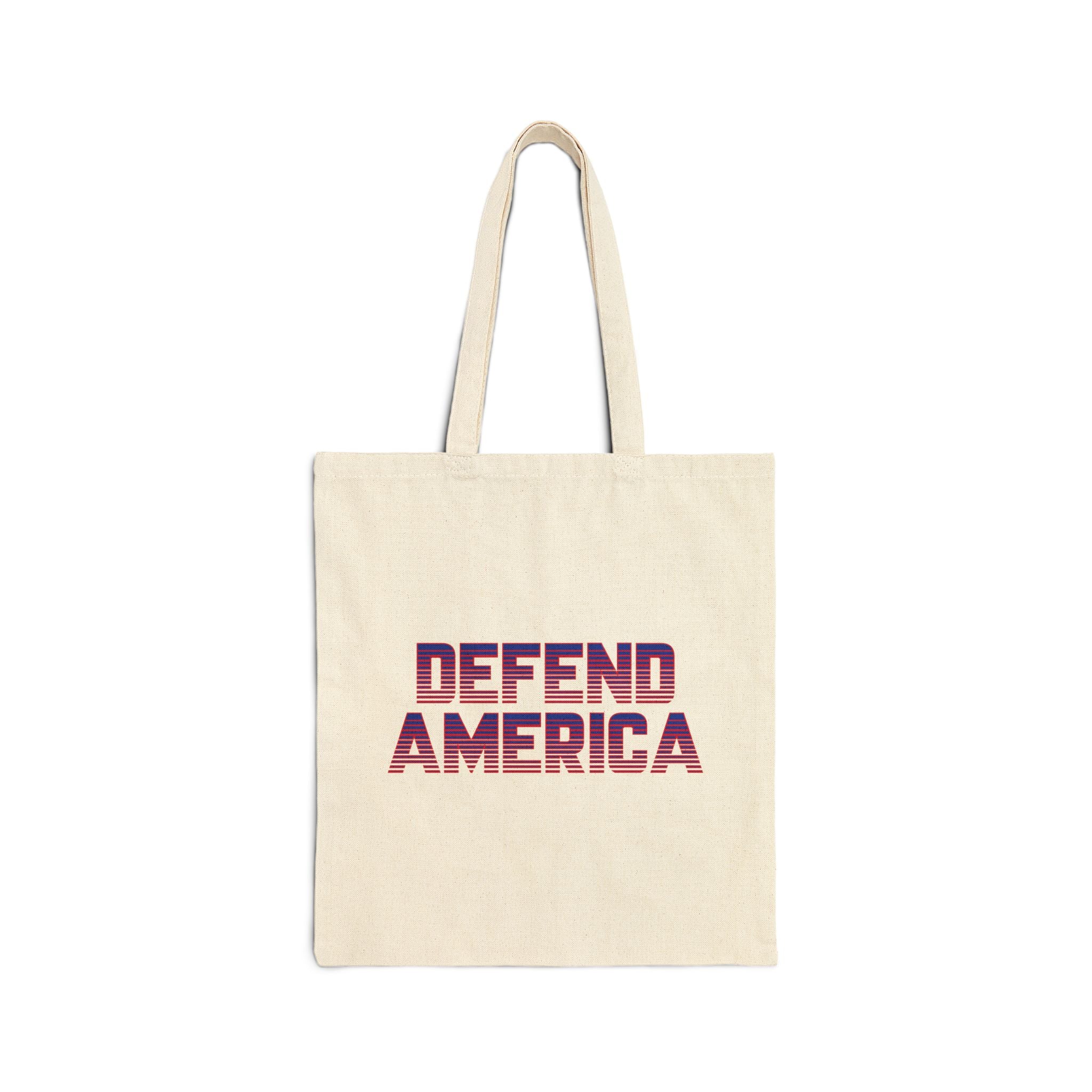 A beige cotton canvas tote bag with 'DEFEND AMERICA' printed in red and purple on the front.