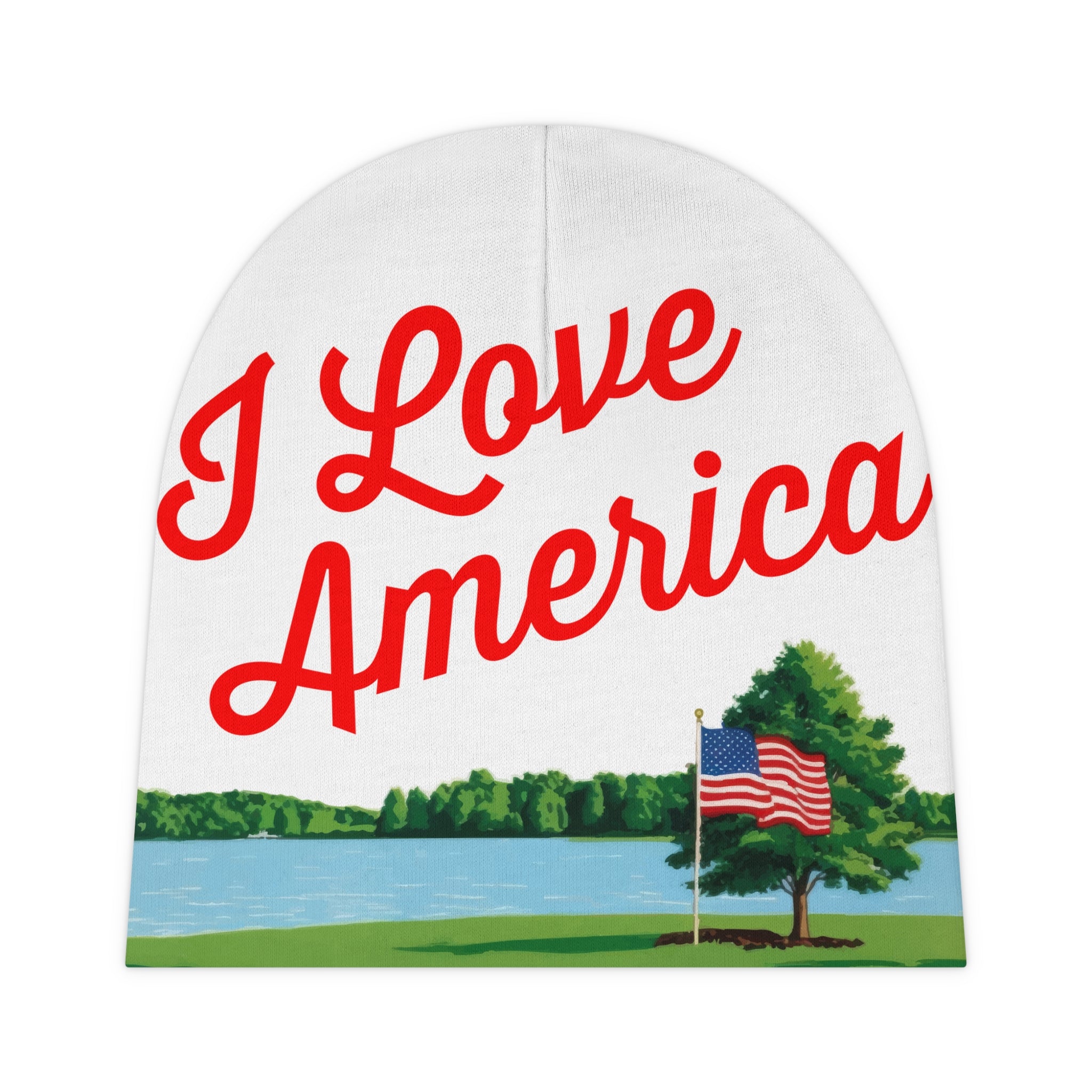 A white baby beanie with 'I Love America' printed in red script across the front, featuring an illustration of an American flag and a tree on a lake background.