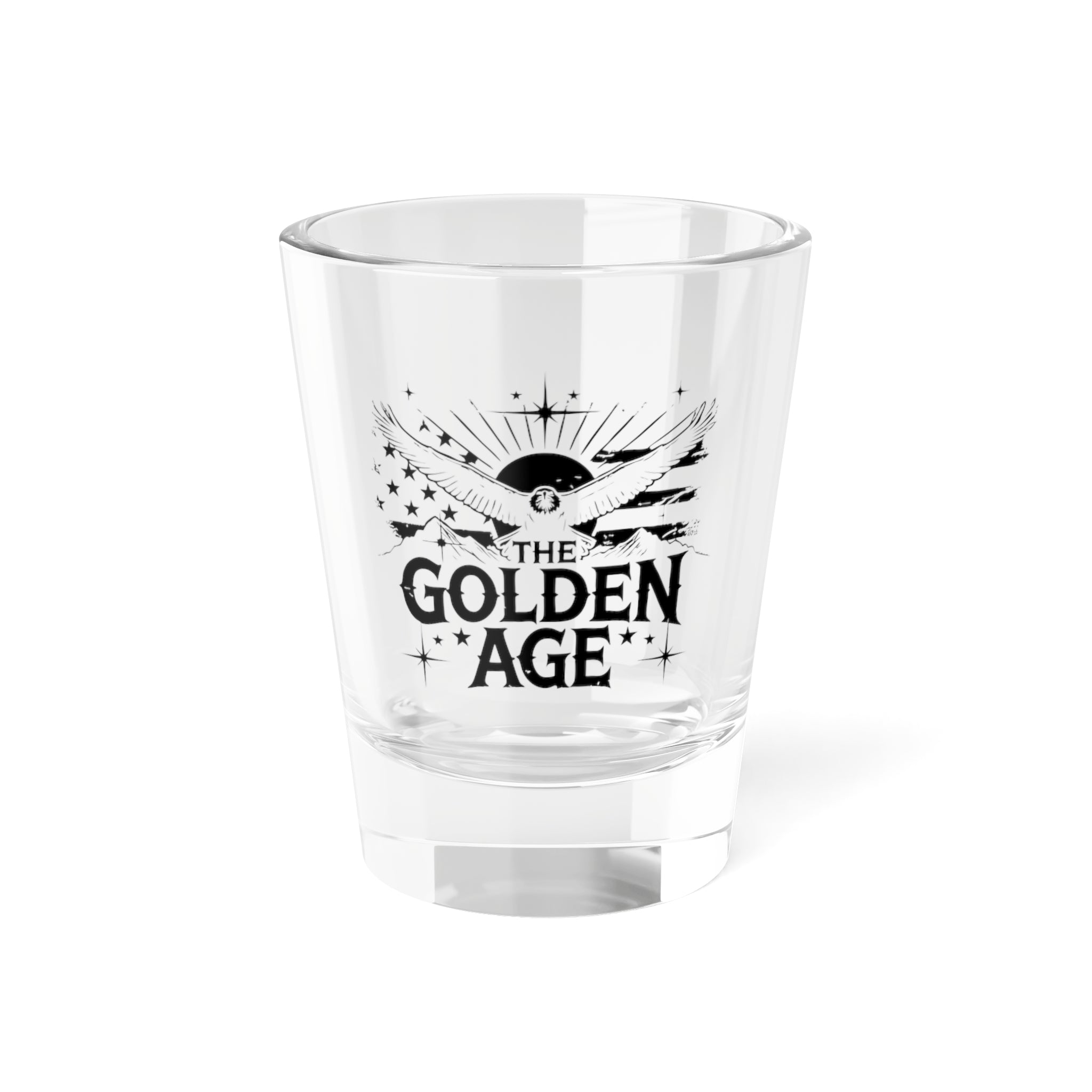 A clear glass shot glass with 'The Golden Age' printed in black text on the front.